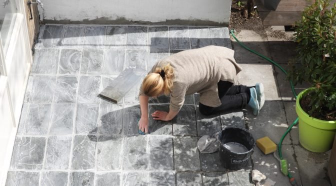 Klusvrouw Nicole Prins legt flagstones in cement